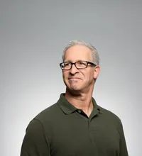 Experienced man with glasses in a green polo shirt